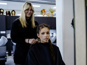 Studente is haren aan het invlechten van haar klant