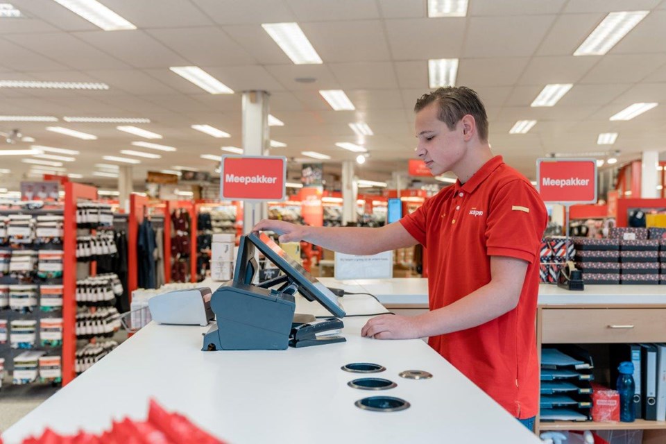 Jongens slaat iets aan op kassa in winkel.