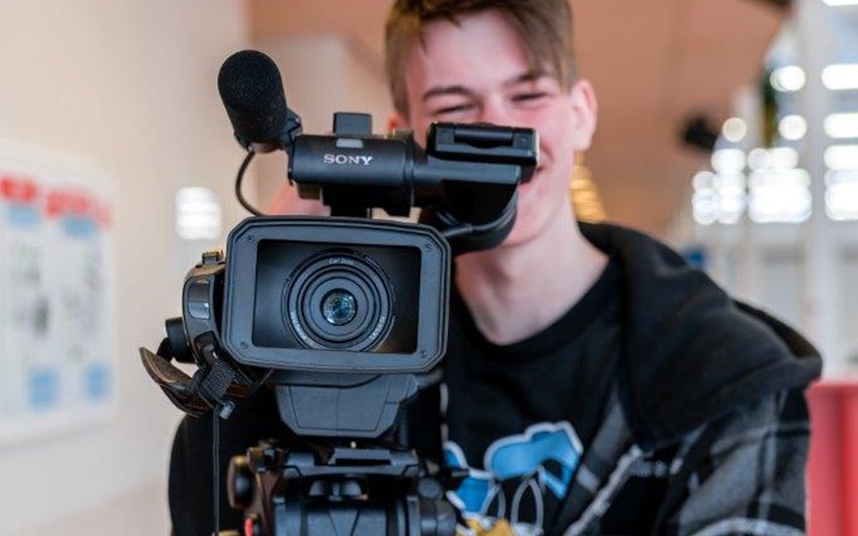 Student mediavormgeving staat achter grote camera