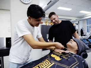 Docent en student barbier tijdens de les