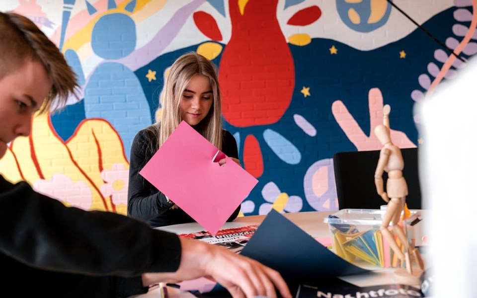 Twee studenten mediavormgeving knippen in gekleurd papier