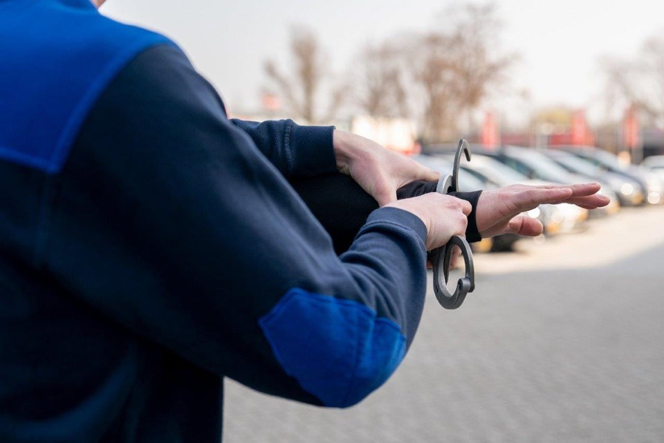 Handhaver slaat iemand in de boeien