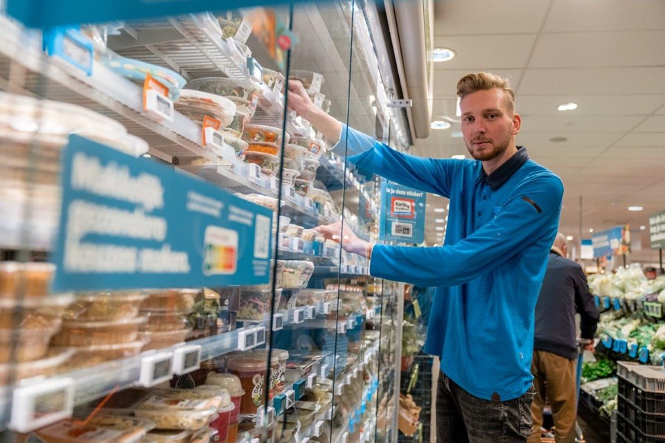 Man zet dingen in koeling supermarkt.