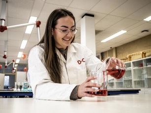 Laboratoriumtechniek Emmen Opleidingsfotografie Lowres 220225 12 Lachende lab student met glazen bekers