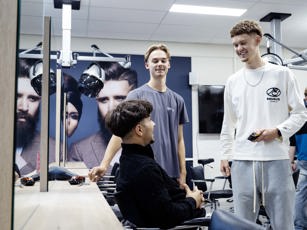 Studenten barbier met elkaar in gesprek tijdens de les