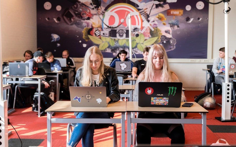 Studenten ICT aan het werk achter laptop in klaslokaal