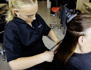 Student is haren aan het knippen tijdens de les