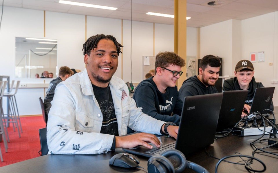 Studenten Software Developer zitten in klaslokaal achter laptop