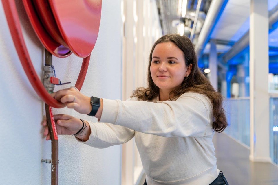 Student Facilitair controleert de brandslang