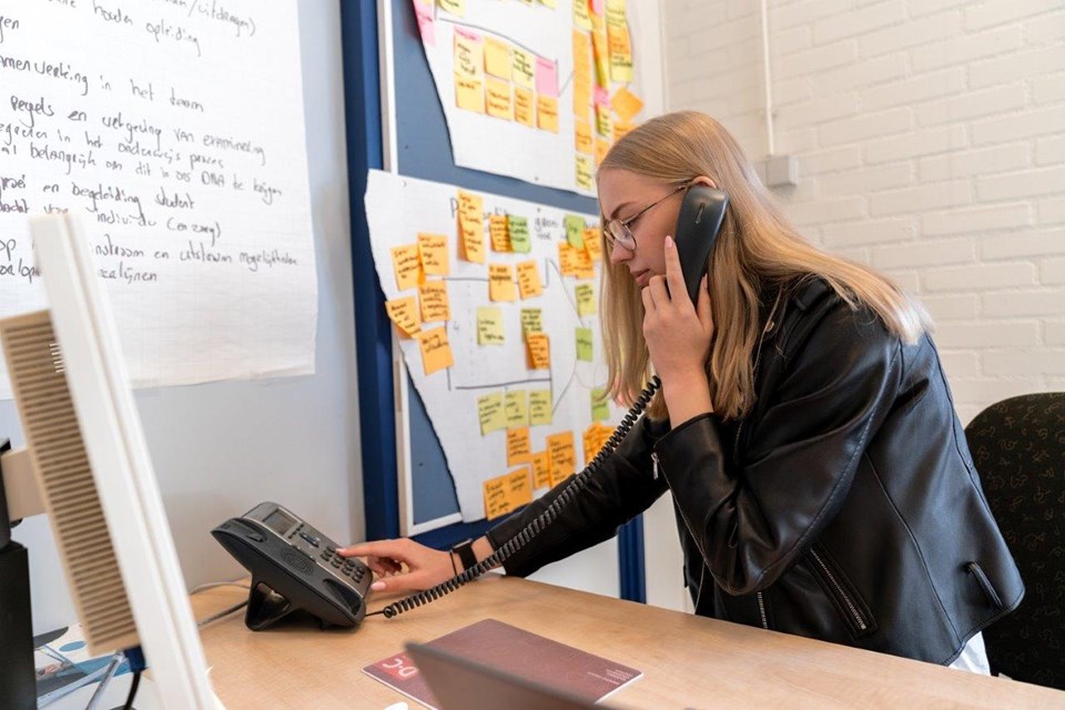 ICT Niveau 3 4 Iris Sijbom 2022 (20) Student ICT tikt nummers in op vaste telefoon op bureau