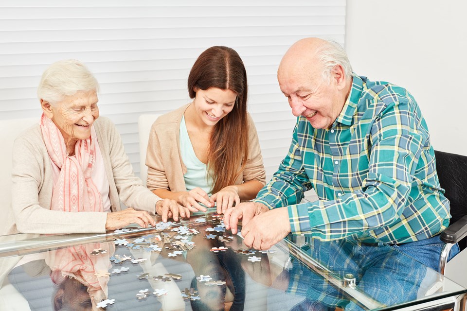 Werk met alle leeftijden Ouderen en verzorger maken puzzel