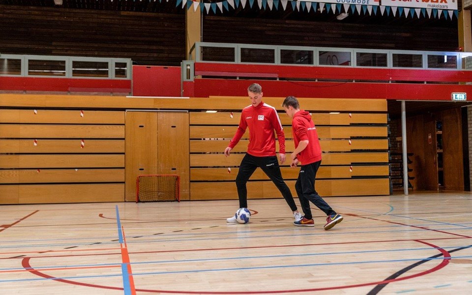 Twee studenten sport en bewegen aan het voetballen in de zaal