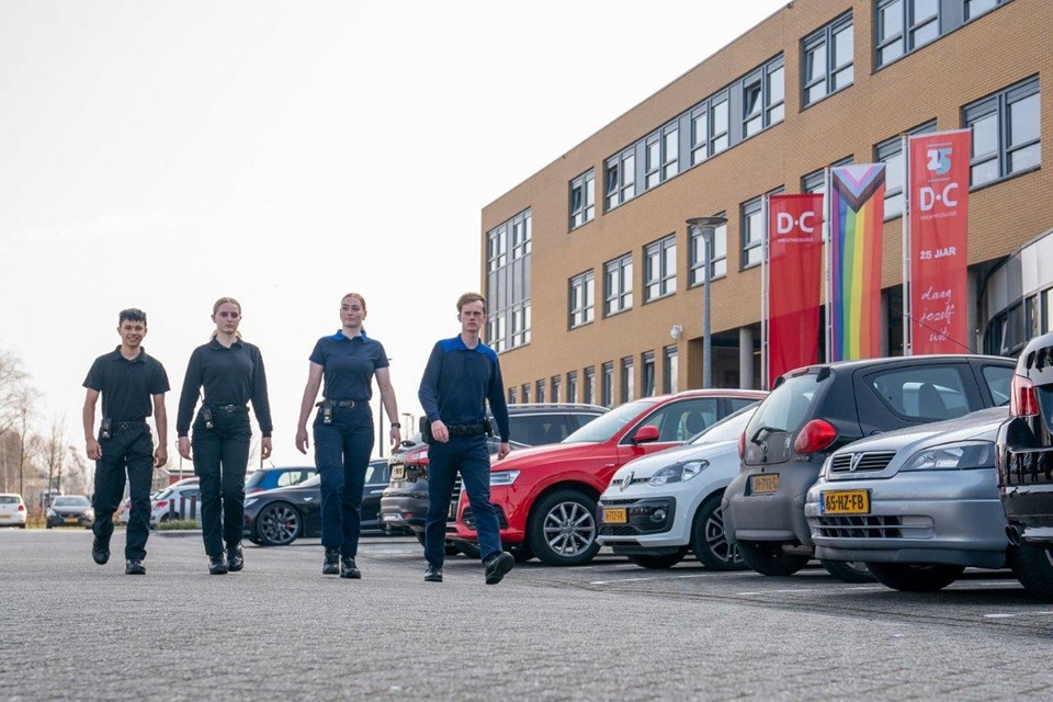 Studenten Handhaving en Beveiliging lopen op de parkeerplaats