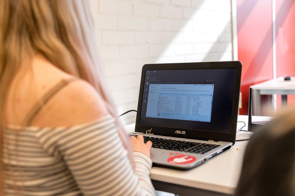 ICT Niveau 3 4 Iris Sijbom 2022 (10) Student ICT van achter die kijkt naar beeldscherm laptop
