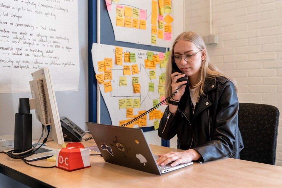 ICT Niveau 3 4 Iris Sijbom 2022 (18) Student ICT bellend met vaste telefoon achter de laptop