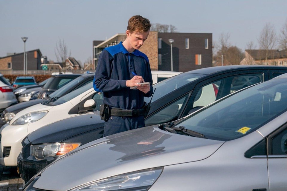 Student handhaving schrijft boete bij auto