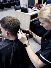 Student barbier haar aan het scheren van klant