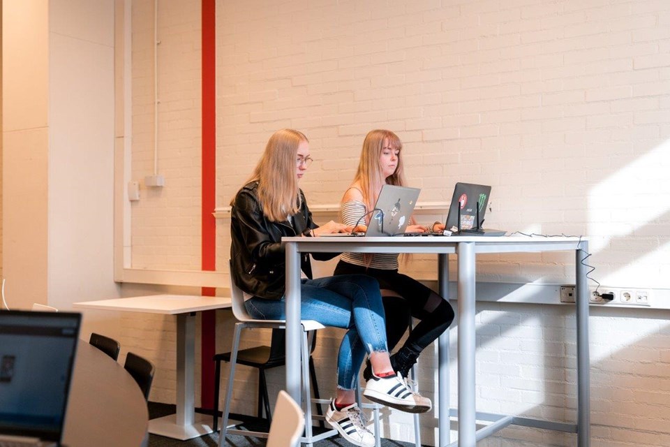 ICT Niveau 3 4 Iris Sijbom 2022 (8) Twee studenten ICT zitten naast elkaar aan hoge tafel achter hun laptop