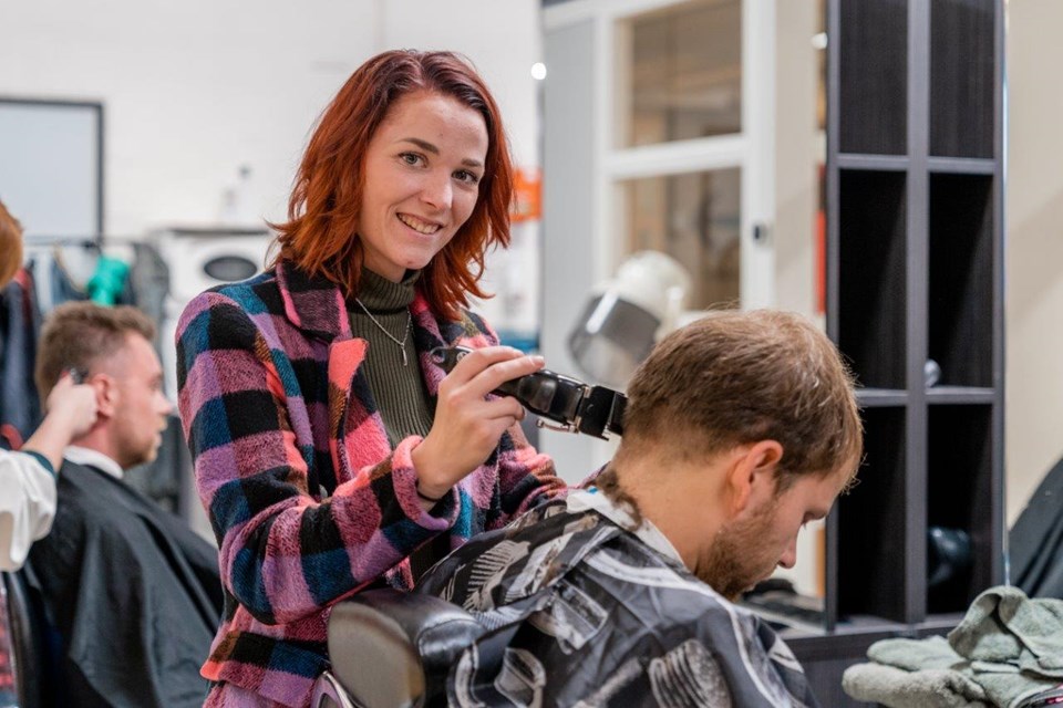 Student Haarstylist Heer gebruikt tondeuse bij man in kappersstoel