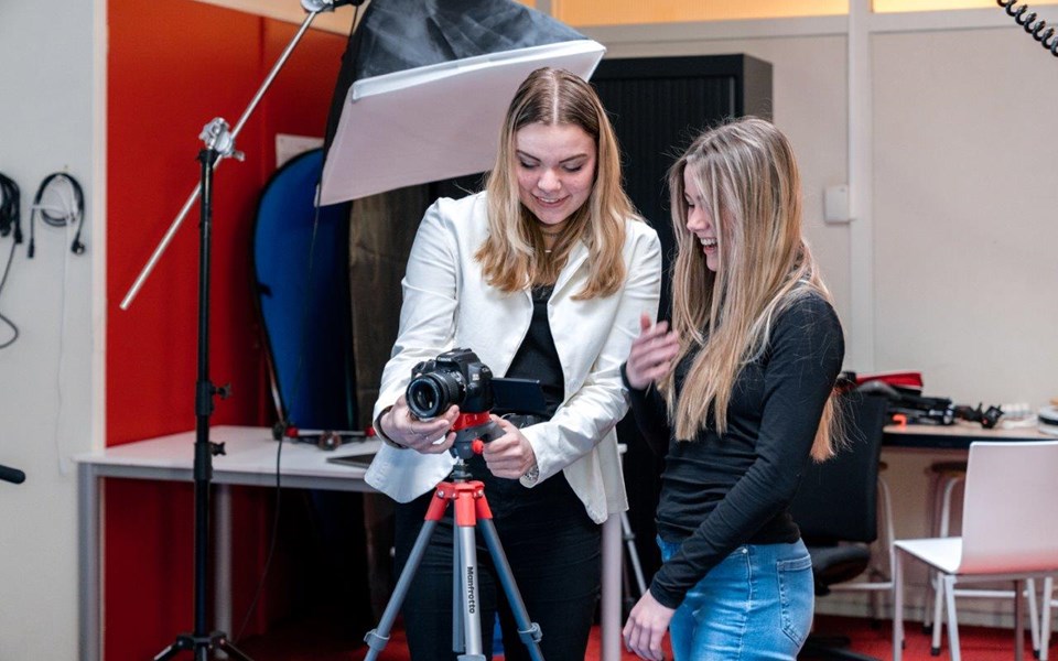 Twee studenten mediavormgeving stellen camera op statief in