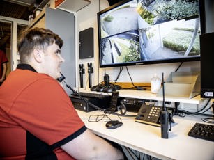 Student beveiliging aan de telefoon terwijl hij de camera checkt