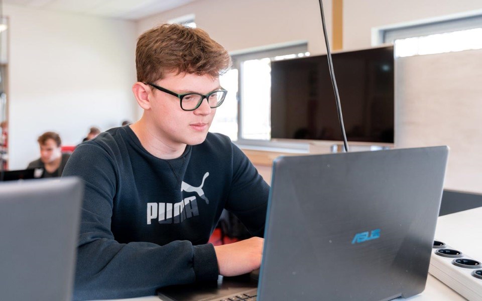 Student Software Developer werkt achter laptop