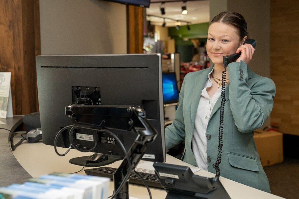 Student werkt achter receptie en neemt telefoon op