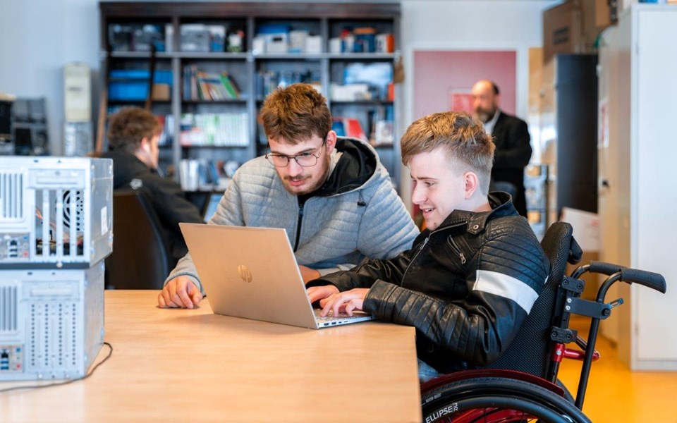 Twee studenten ICT Support werken samen op een laptop