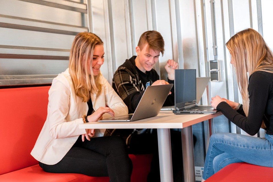 Mediavormgever, Iris Sijbom 2022 (23) Drie mediavormgevers in opleiding zittend aan het werk op hun laptop bij tafel