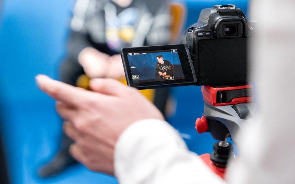 Student mediavormgeving neemt beelden op met camera van persoon in stoel