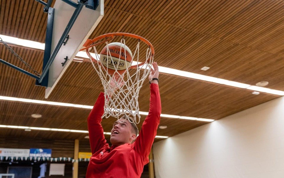 Student sport en bewegen hangend aan de basket