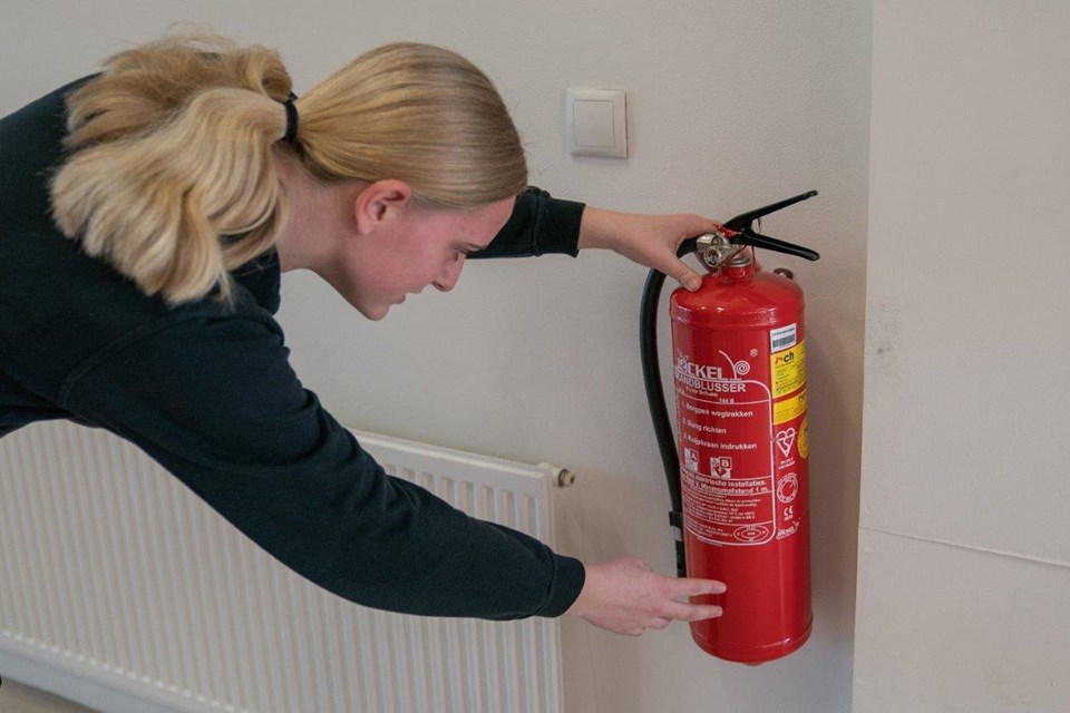 Beveiliger inspecteert brandblusser