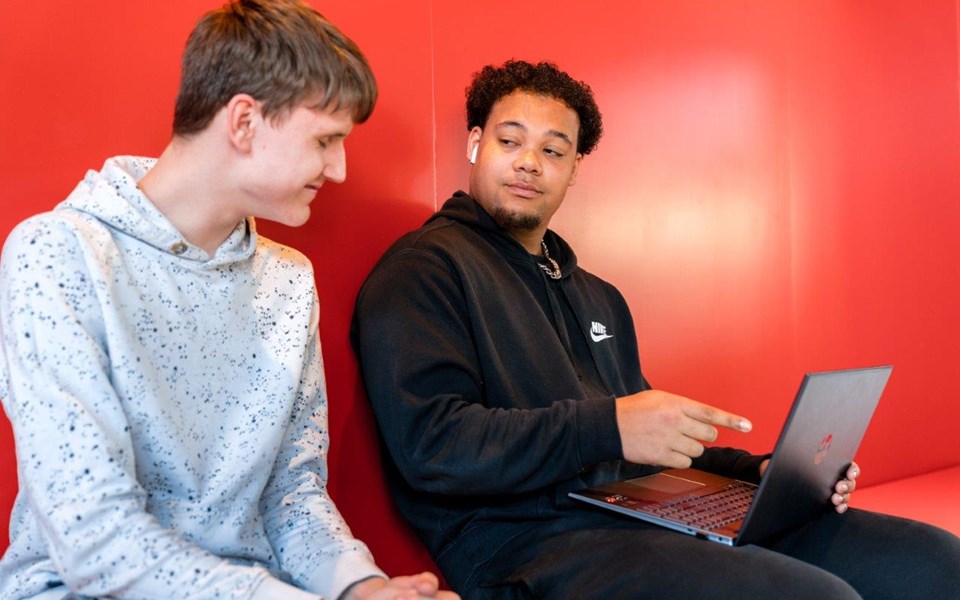 Student Medewerker ICT Support wijst medestudent iets aan op de laptop
