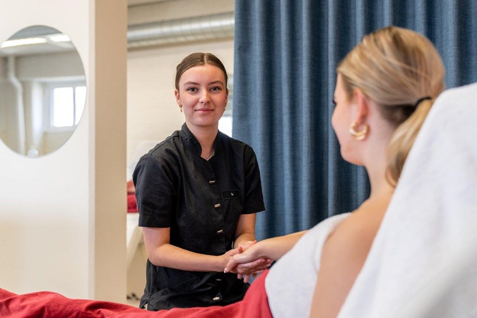 Schoonheidsverzorging + Salon, Iris Sijbom 2022 (8) Schoonheidsspecialist in opleiding behandelt hand van klant in stoel