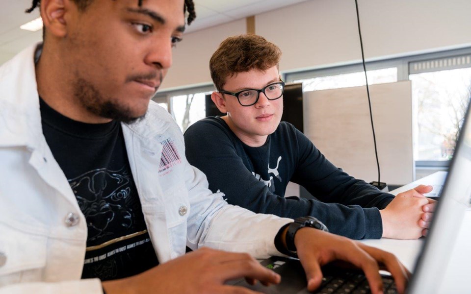 Twee studenten Software Developer kijken samen naar één laptop