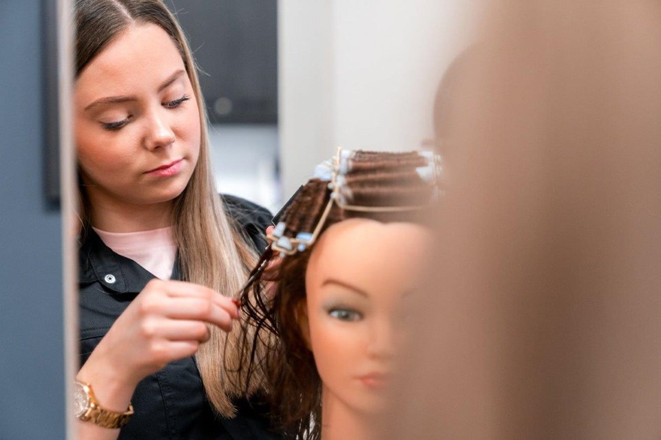 Haarverzorging + Salon Iris Sijbom 2022 (18) Kapper in opleiding brengt krulspelden aan in haar van pop