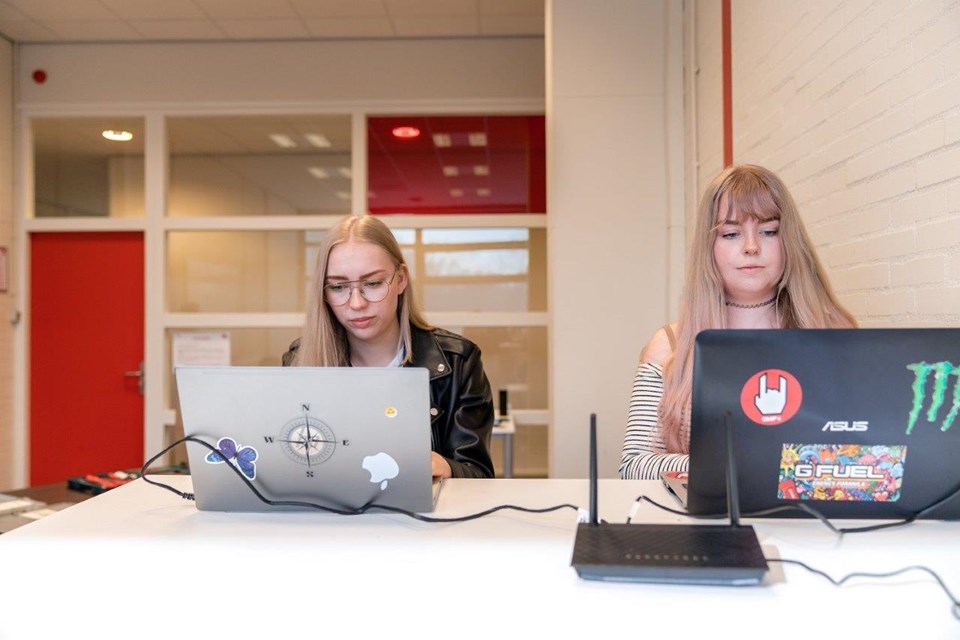 ICT Niveau 3 4 Iris Sijbom 2022 (7) Twee studenten ICT zitten naast elkaar aan tafel en werken achter laptop
