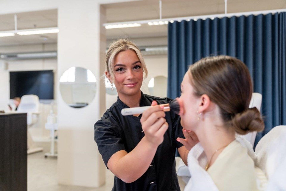 Schoonheidsverzorging + Salon, Iris Sijbom 2022 (3) Schoonheidsspecialist in opleiding brengt poeder aan met kwast op gezicht klant