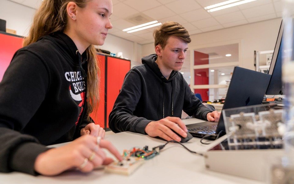 Studenten Elektrotechniek werken samen op laptop 
