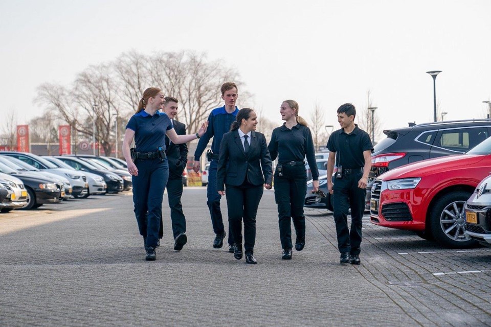 Groep studenten Handhaving en Beveiliging op parkeerplaats
