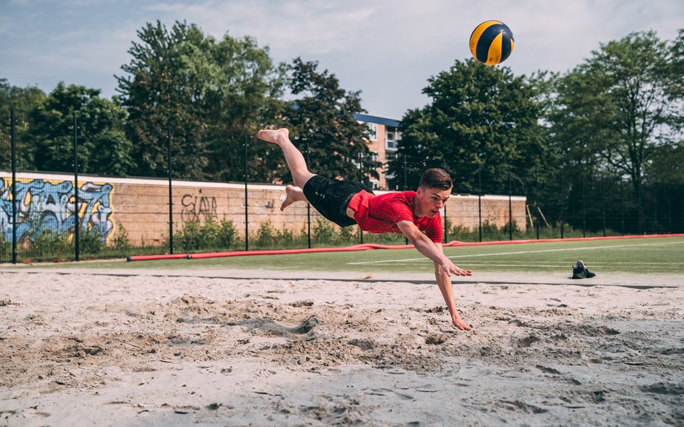 Student sport en bewegen duikt achter volleybal aan