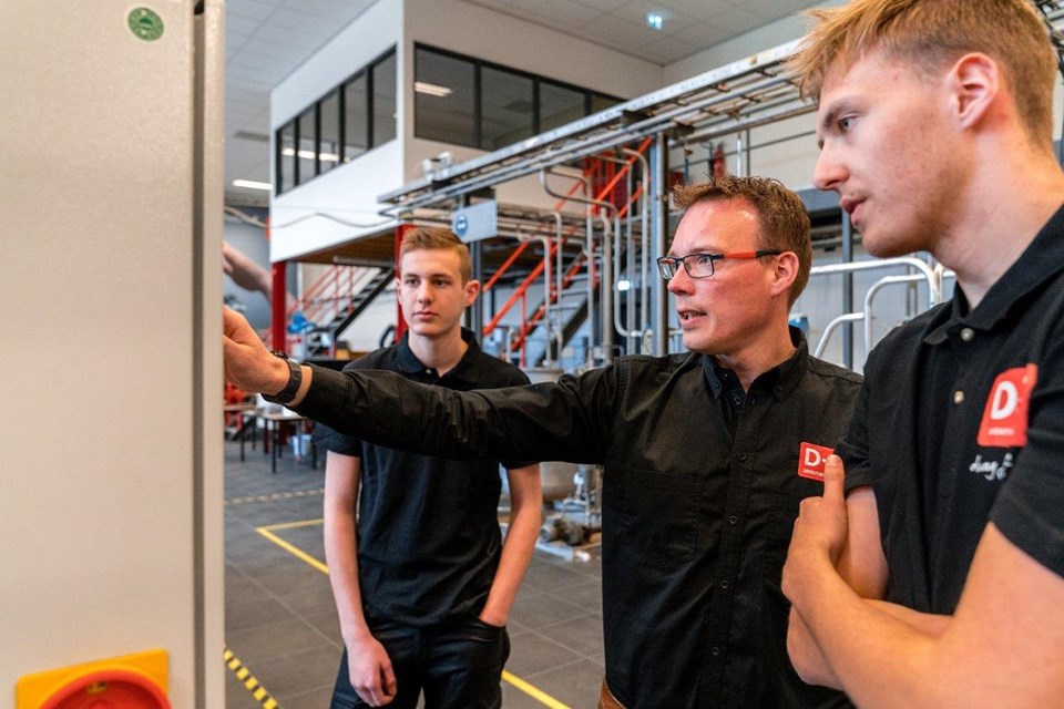 Twee studenten krijgen uitleg van docent