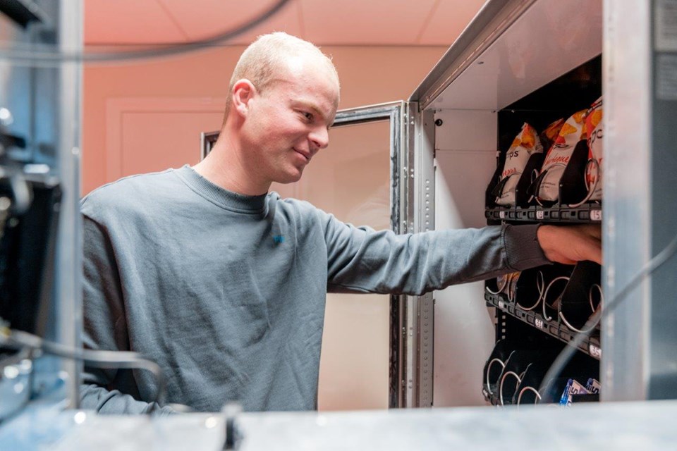 Student Facilitair vult de automaat bij